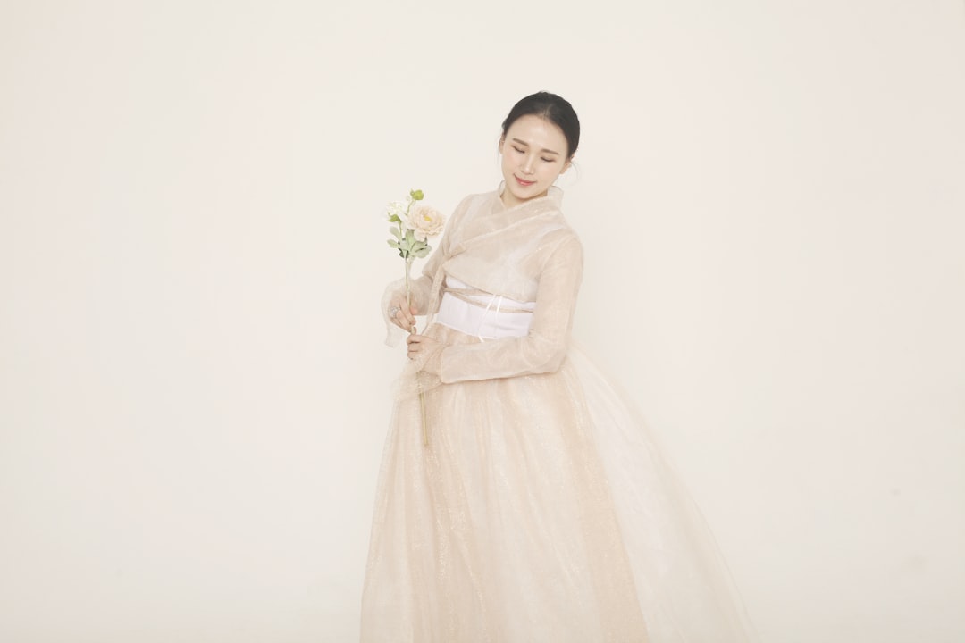 woman in white dress holding bouquet of flowers, Hanbok Korean Traditional Dress<p></figure>photographer_ Baek Gayeon (@__g_yn__)