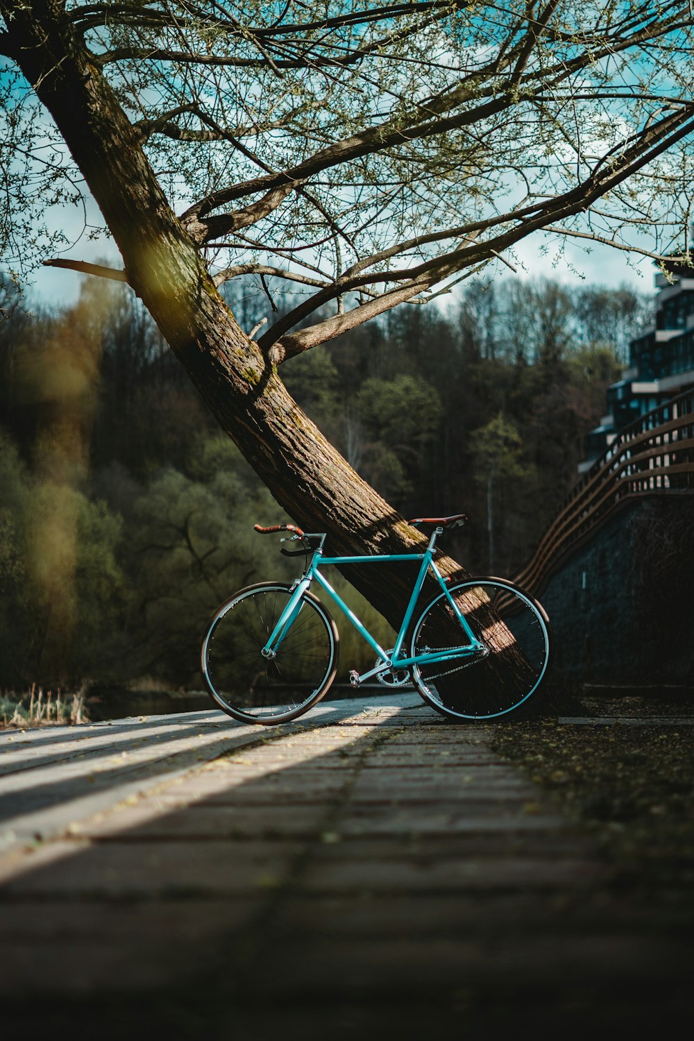 Bicicleta urbana azul en puente de madera