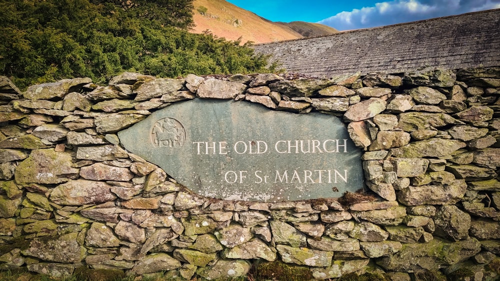 a stone wall with a sign that says the old church of st martin