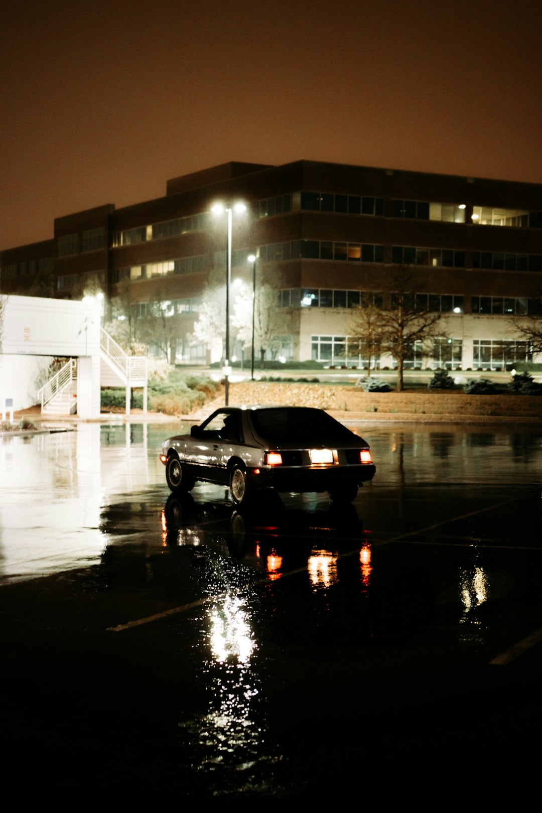 black sedan parked beside building during night time