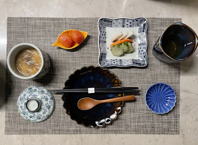 Meiji Japan dinner setting featuring elegant lacquerware and kimono-clad hosts.
