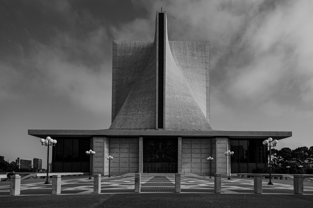 grayscale photo of building under cloudy sky