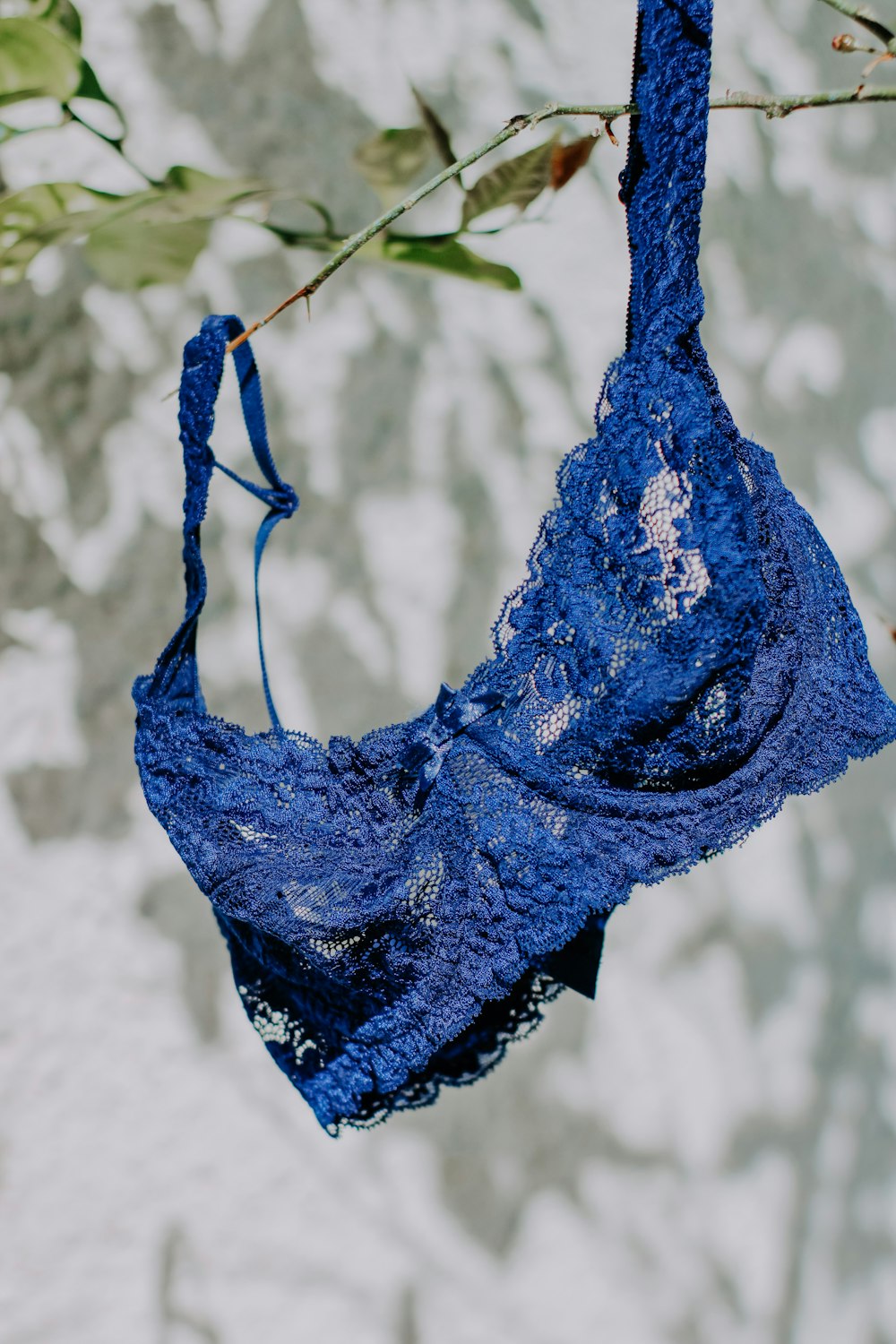 blue lace brassiere on white textile