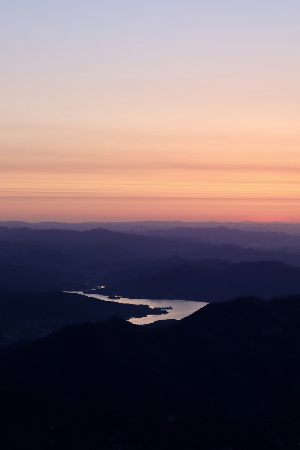 white airplane flying over the mountains during sunset