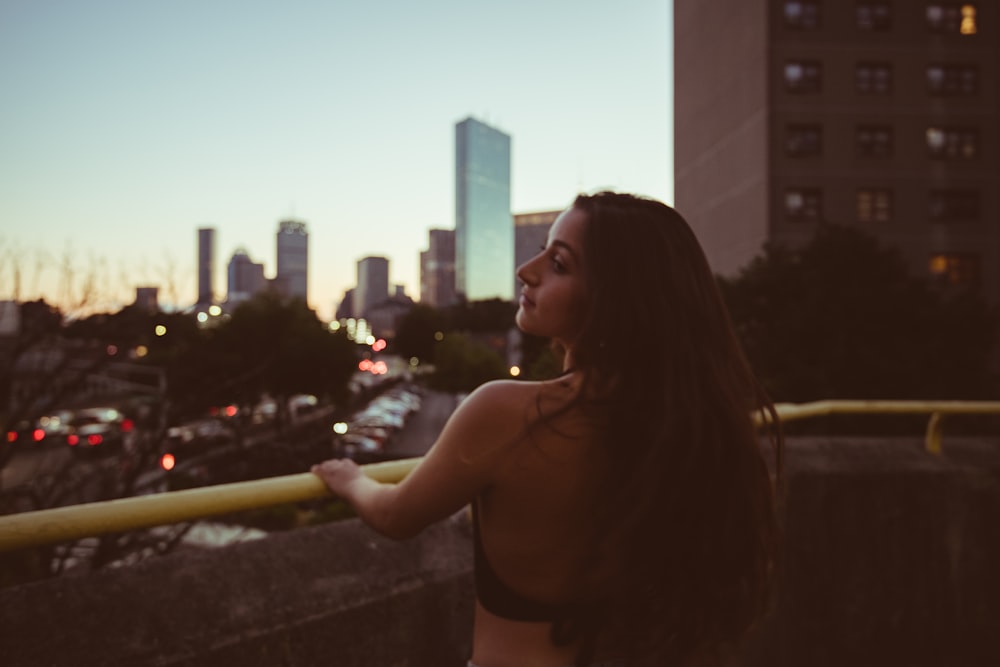 woman in black brassiere smoking cigarette during night time