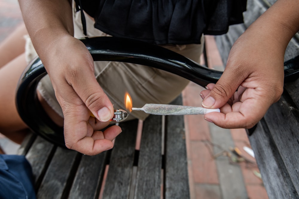 personne tenant un briquet argenté et noir