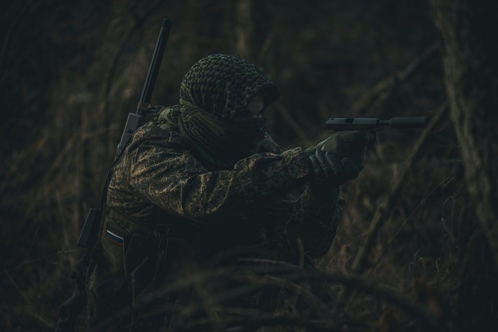 Hombre con chaqueta negra sosteniendo un rifle negro