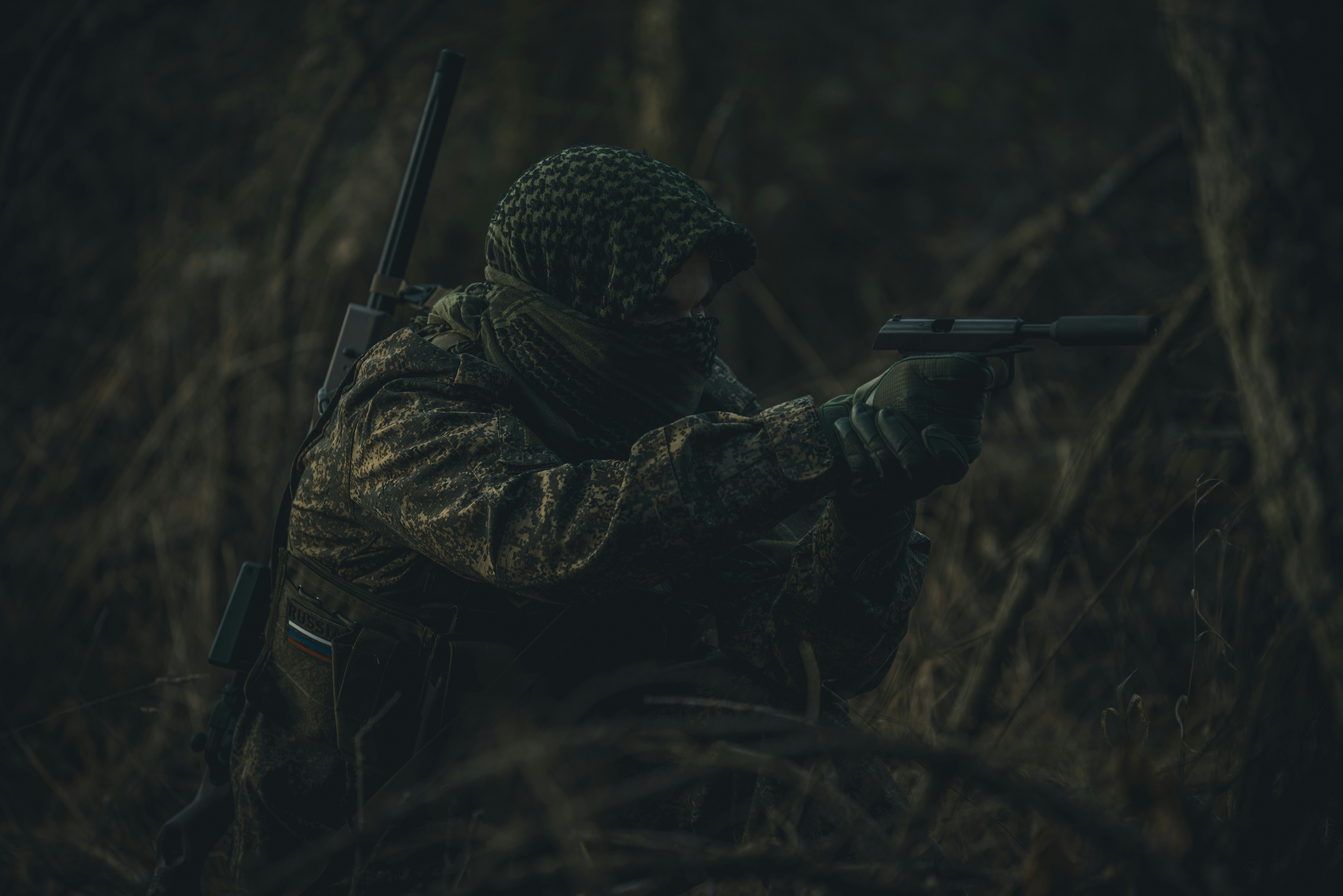 man in black jacket holding black rifle