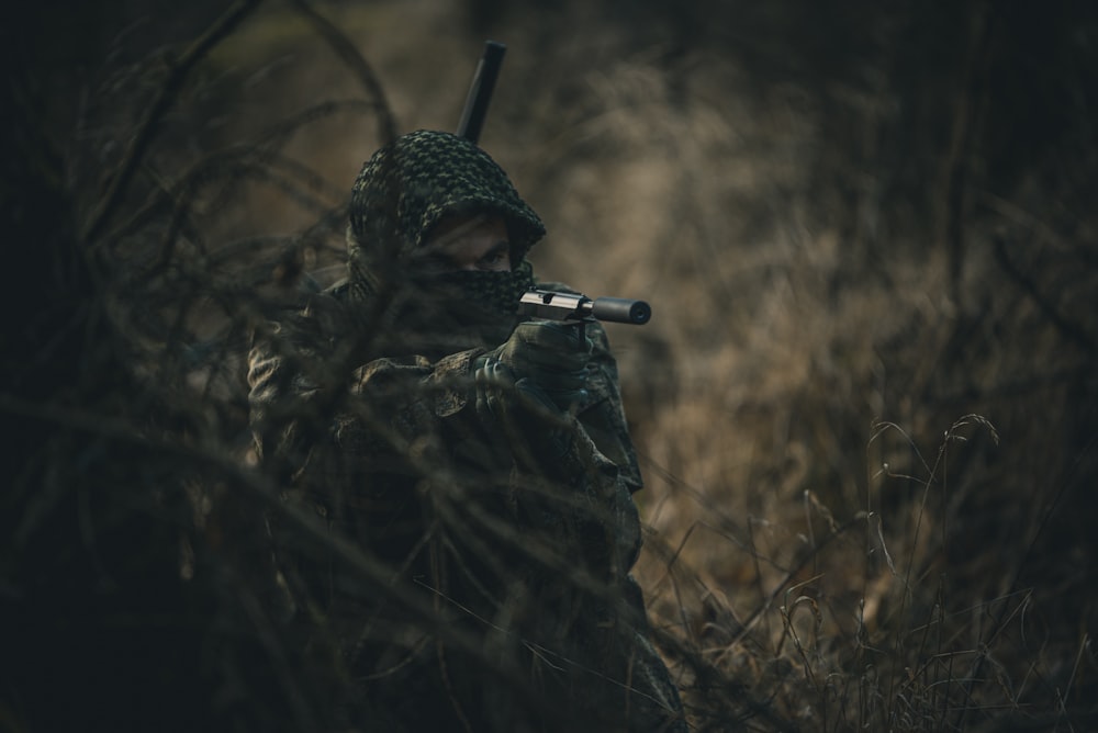 person in black and white hoodie holding black rifle