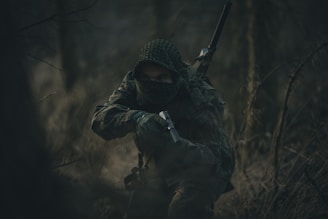 person in black and white hoodie holding rifle