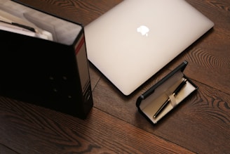 silver macbook on brown wooden table