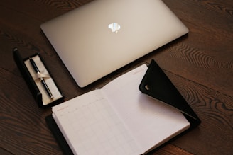 silver macbook on brown table