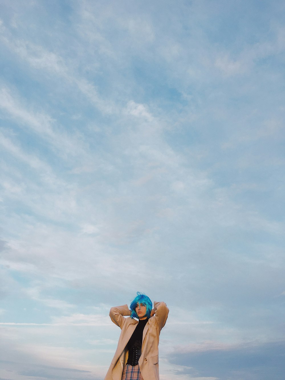 mulher na parte superior do biquíni azul e duques margaridas jeans azuis sentados na praia durante o dia