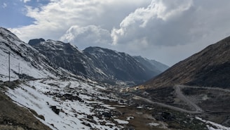 snow covered mountain under cloudy sky during daytime