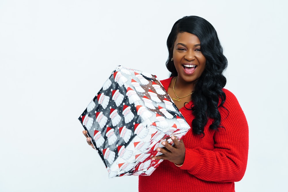 woman in red sweater holding white red and gray gift box
