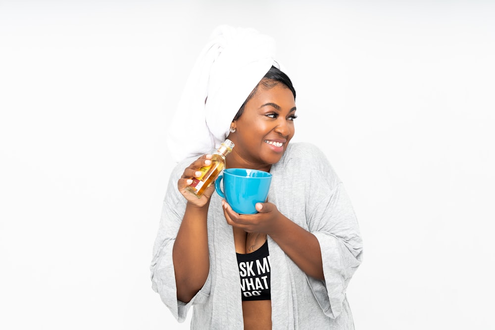 woman in gray long sleeve shirt drinking from blue plastic cup