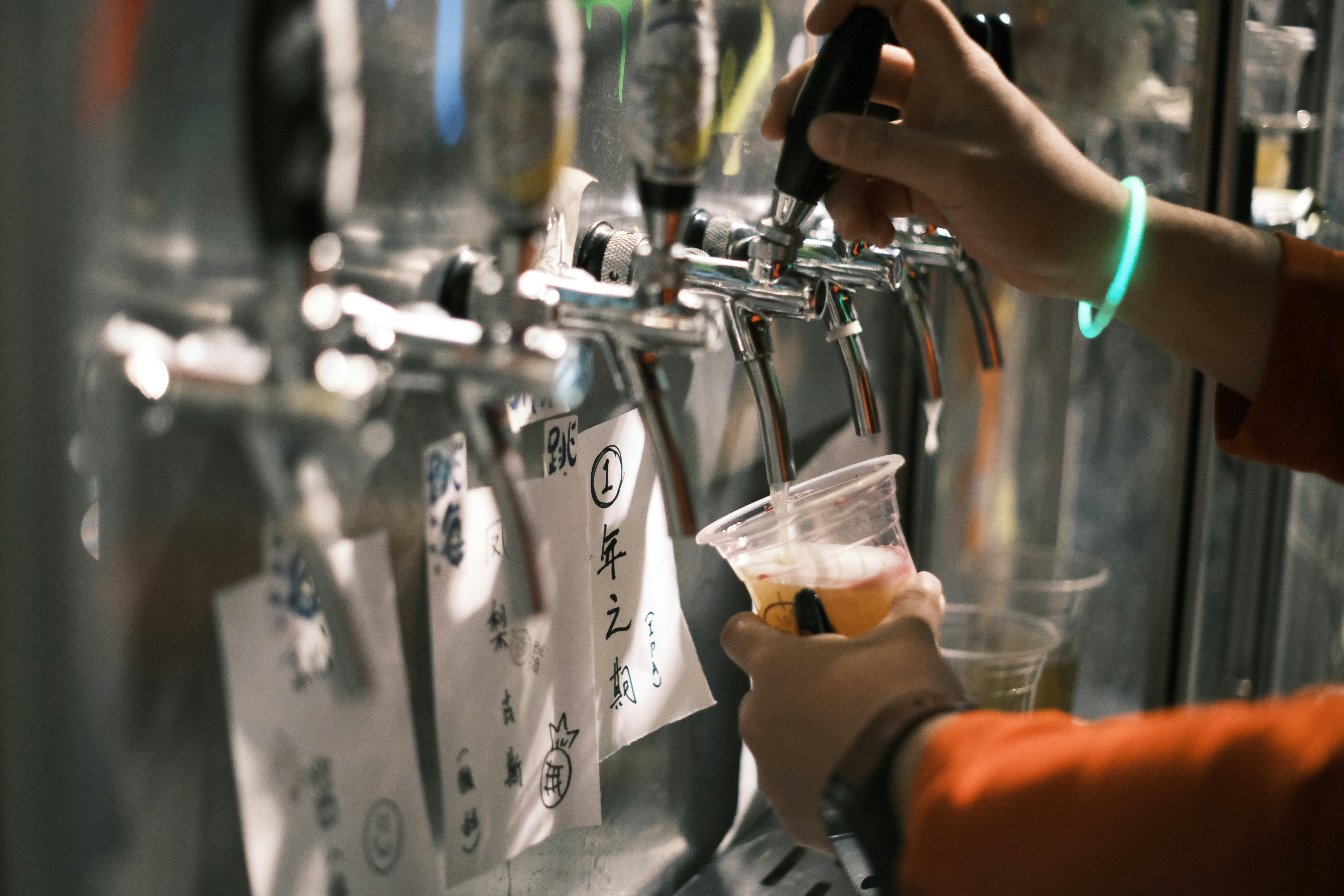Person pouring from a row of beer taps
