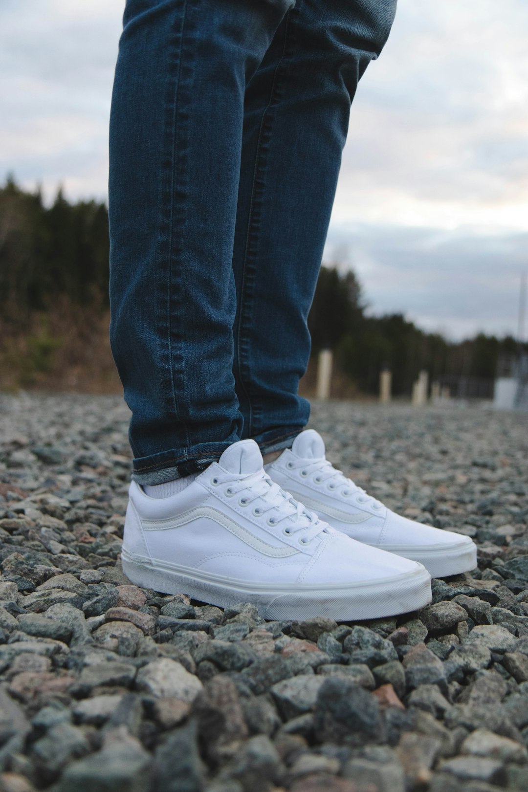 person in blue denim jeans and white nike sneakers