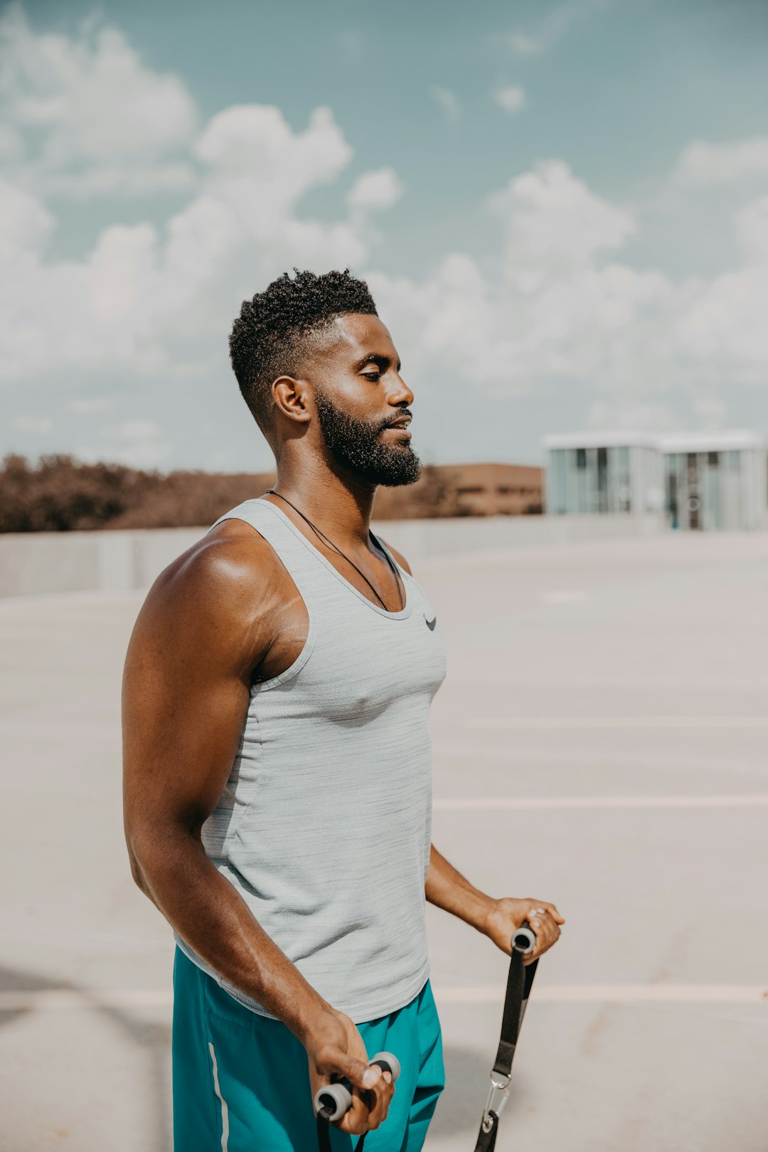 man in white tank top standing on white sand during daytime