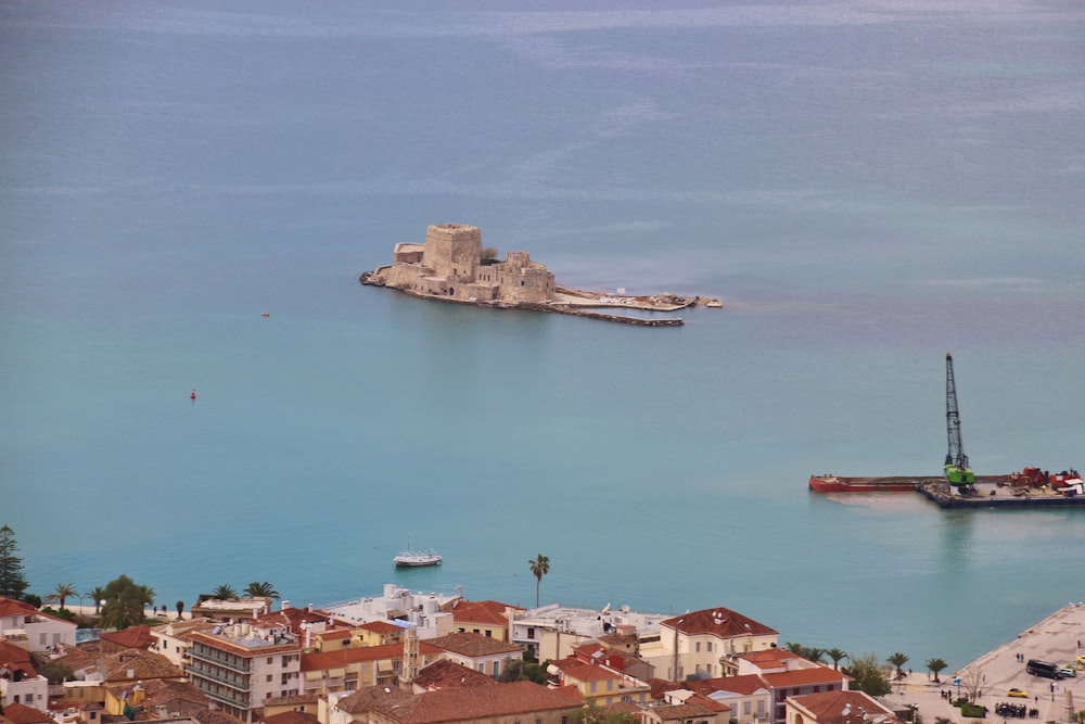 edifícios de concreto marrom e branco ao lado do mar durante o dia