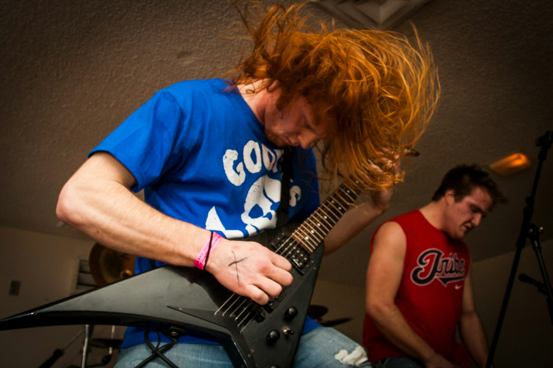 woman in blue crew neck t-shirt playing electric guitar