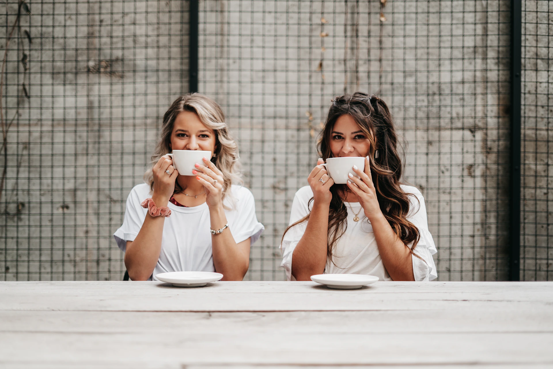 woman in white shirt drinking from white ceramic mug