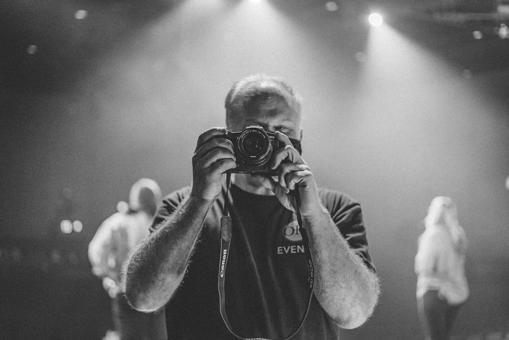 man in black hoodie holding camera