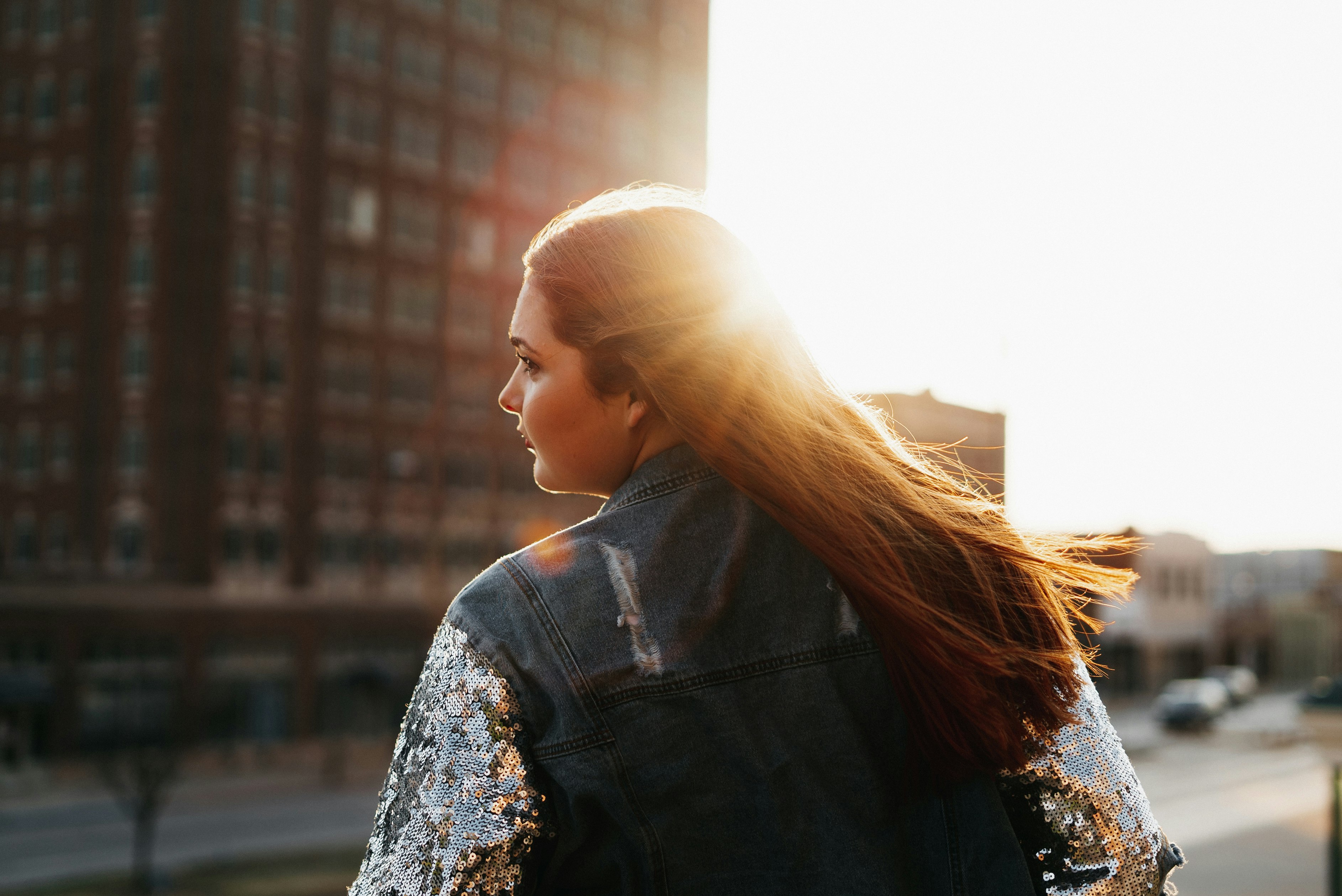 woman in black and white floral shirt looking at the window during daytime