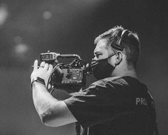 man in black crew neck t-shirt holding black dslr camera