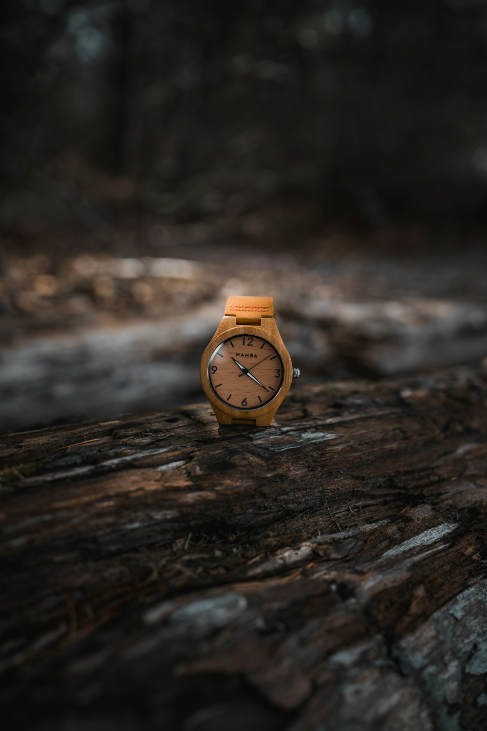 orange and white analog watch on brown wooden surface