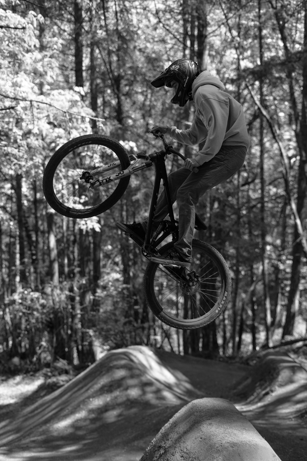 grayscale photo of man riding bicycle