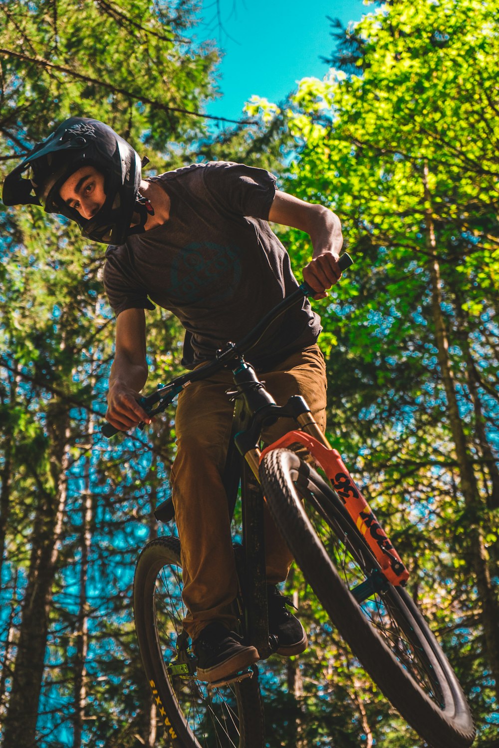 man in brown shirt riding bicycle