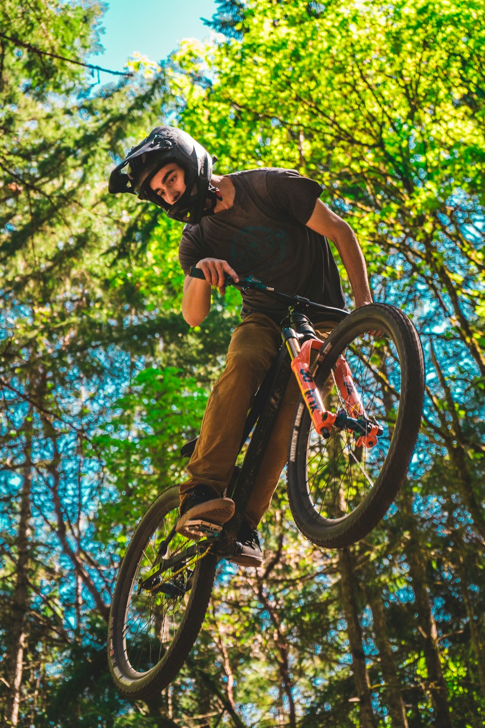 man in brown t-shirt riding on bicycle