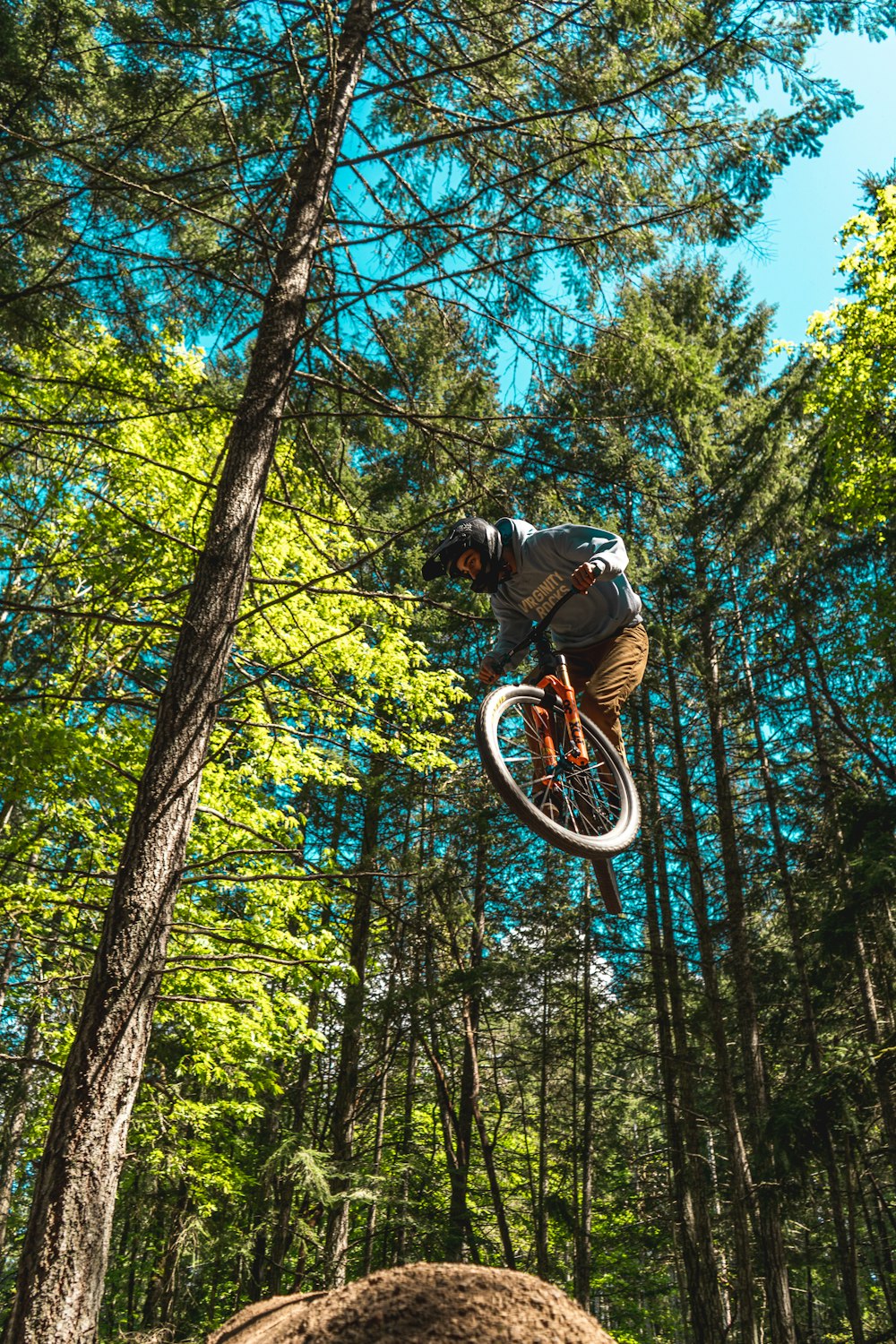 man in black jacket riding bicycle in the forest during daytime