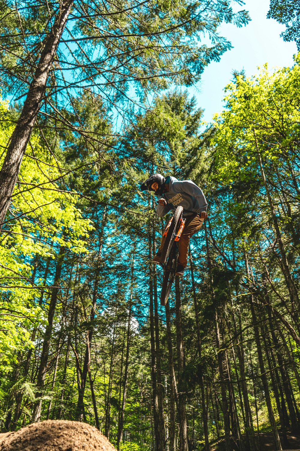 man in brown jacket and black pants climbing on tree during daytime