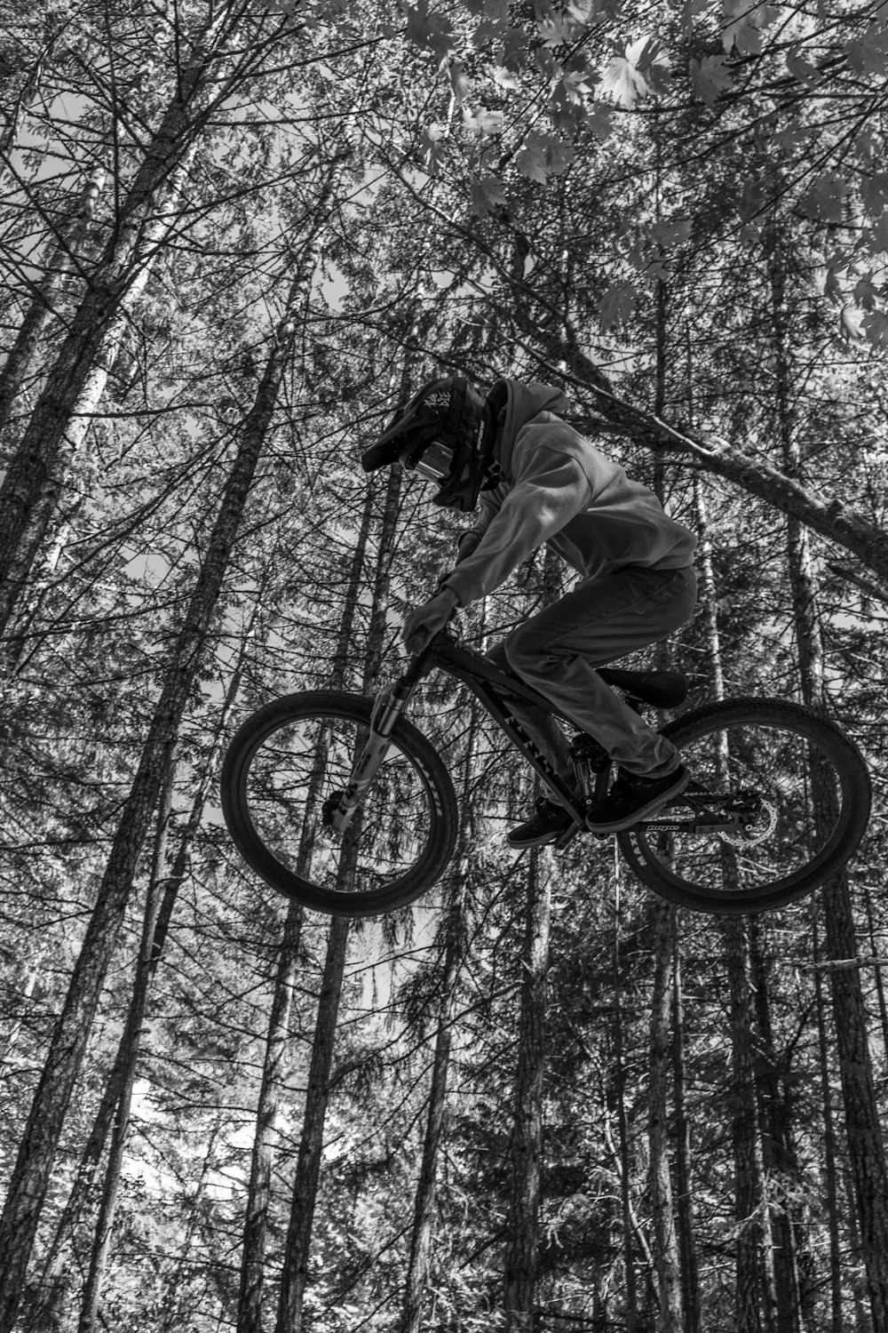 grayscale photo of man riding bicycle