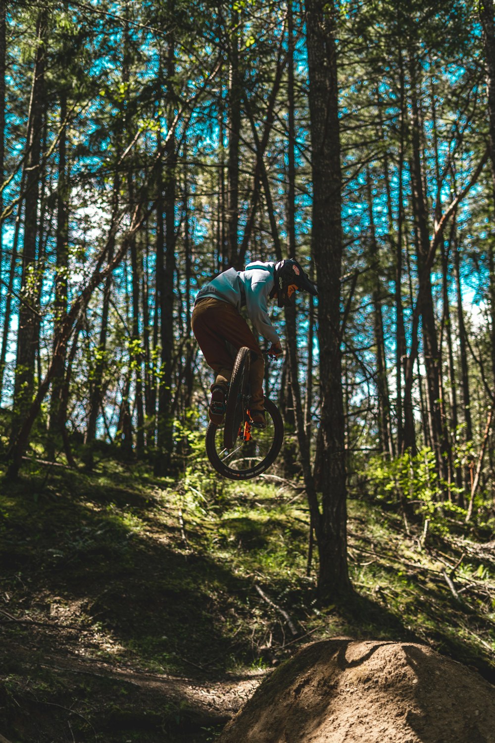 man in black jacket riding bicycle in forest during daytime