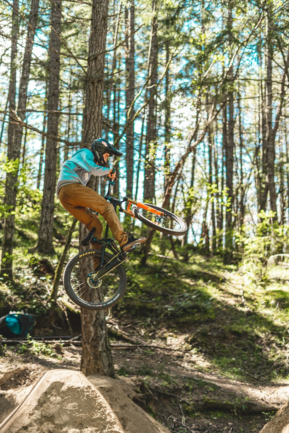 man in blue t-shirt riding on bicycle in forest during daytime