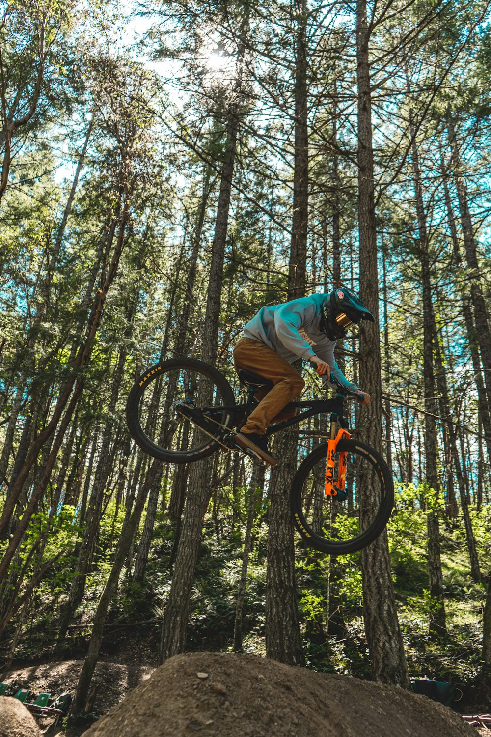 man in blue t-shirt riding bicycle in forest during daytime