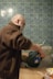 man in brown coat holding blue plastic container