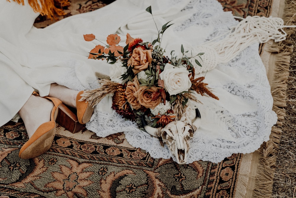 woman in white dress lying on brown and white floral textile