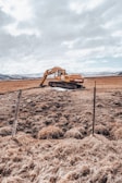 A technician inspecting earth moving equipment in a field.