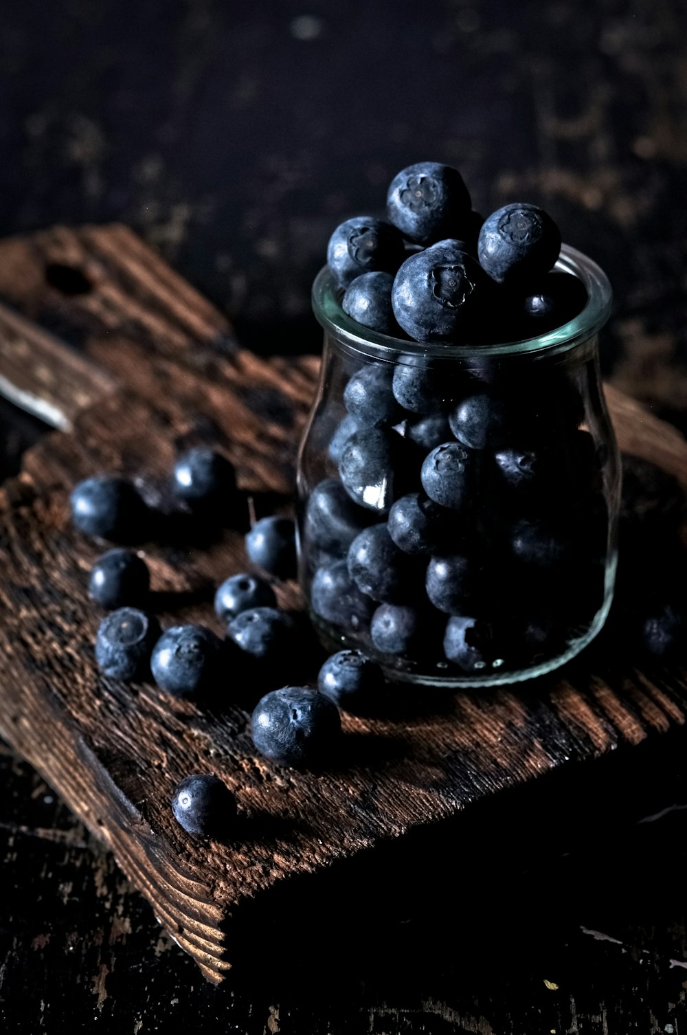 baies noires dans un bocal en verre transparent