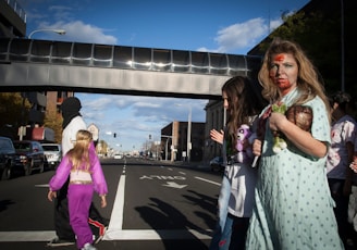 2 women standing on gray concrete road during daytime