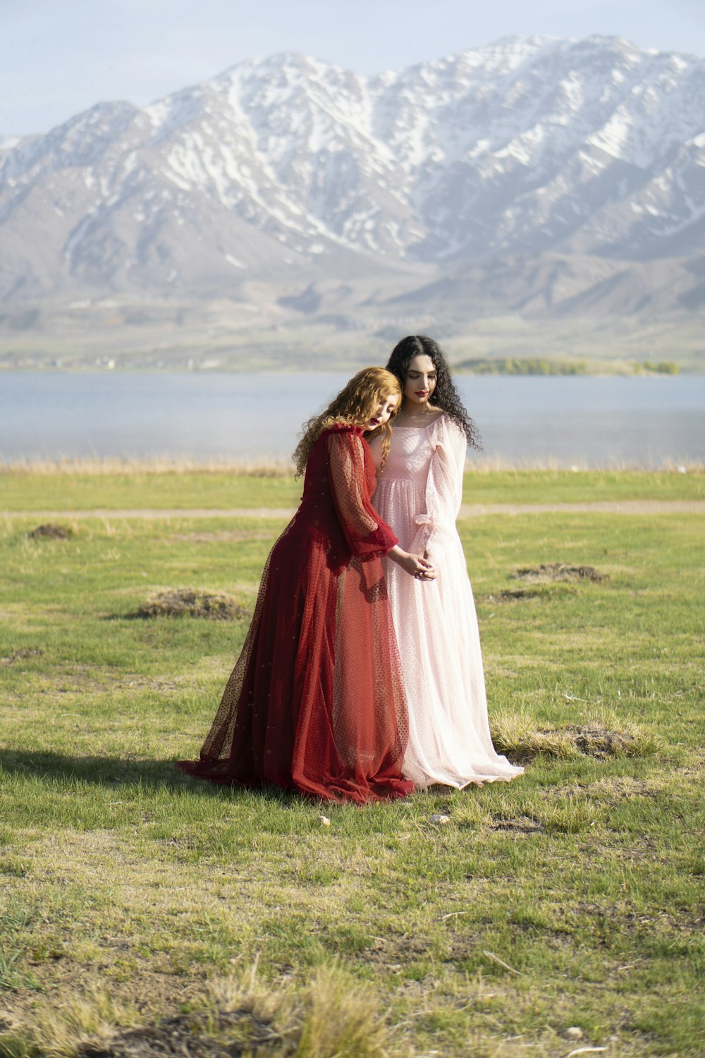 woman in red dress standing on green grass field during daytime