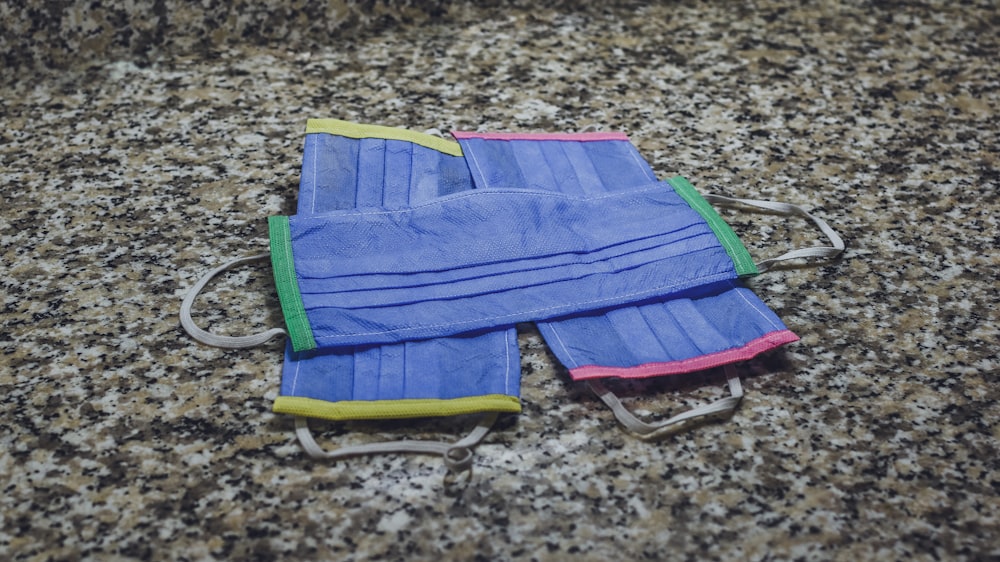 blue and green striped textile on brown and black marble table