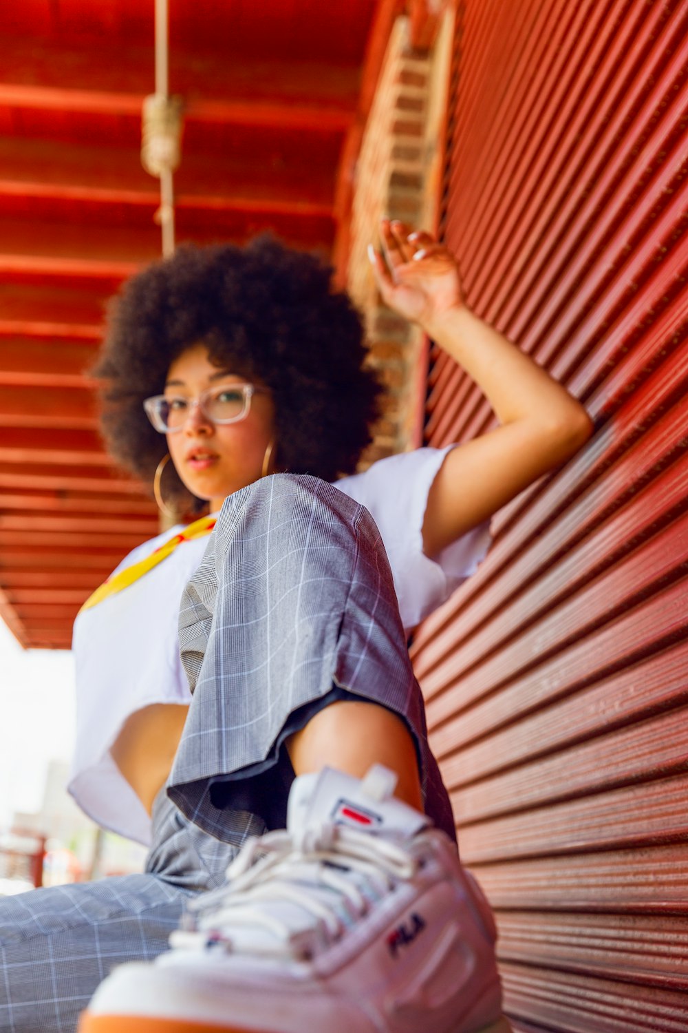 woman in white and blue plaid shirt sitting on brown wooden bench