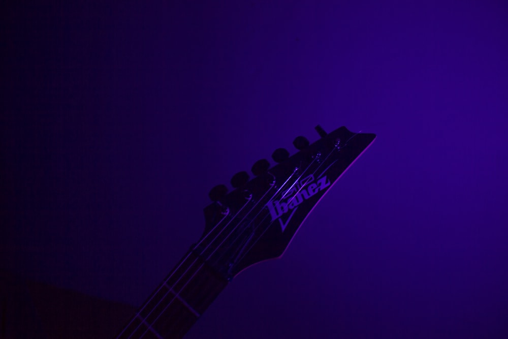 black electric guitar on purple background