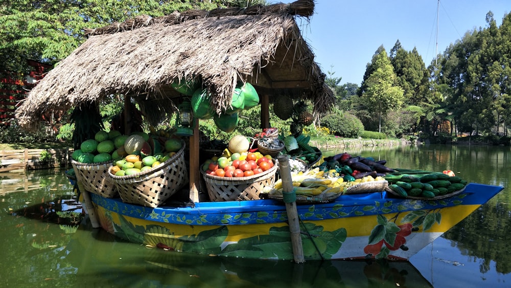 brown nipa hut surrounded by fruits on green wooden boat on water