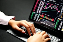 Close-up of hands analyzing charts and graphs on a laptop screen.